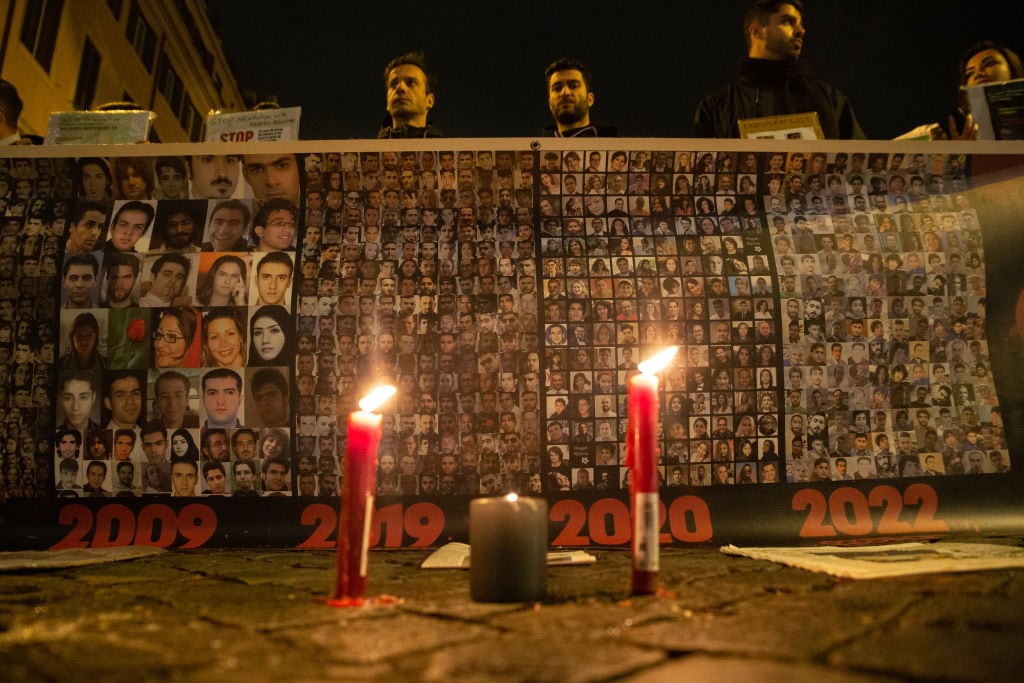 Protesta contra la represión en Irán, que muestra un cartel con los rostros de los muertos a manos del régimen.