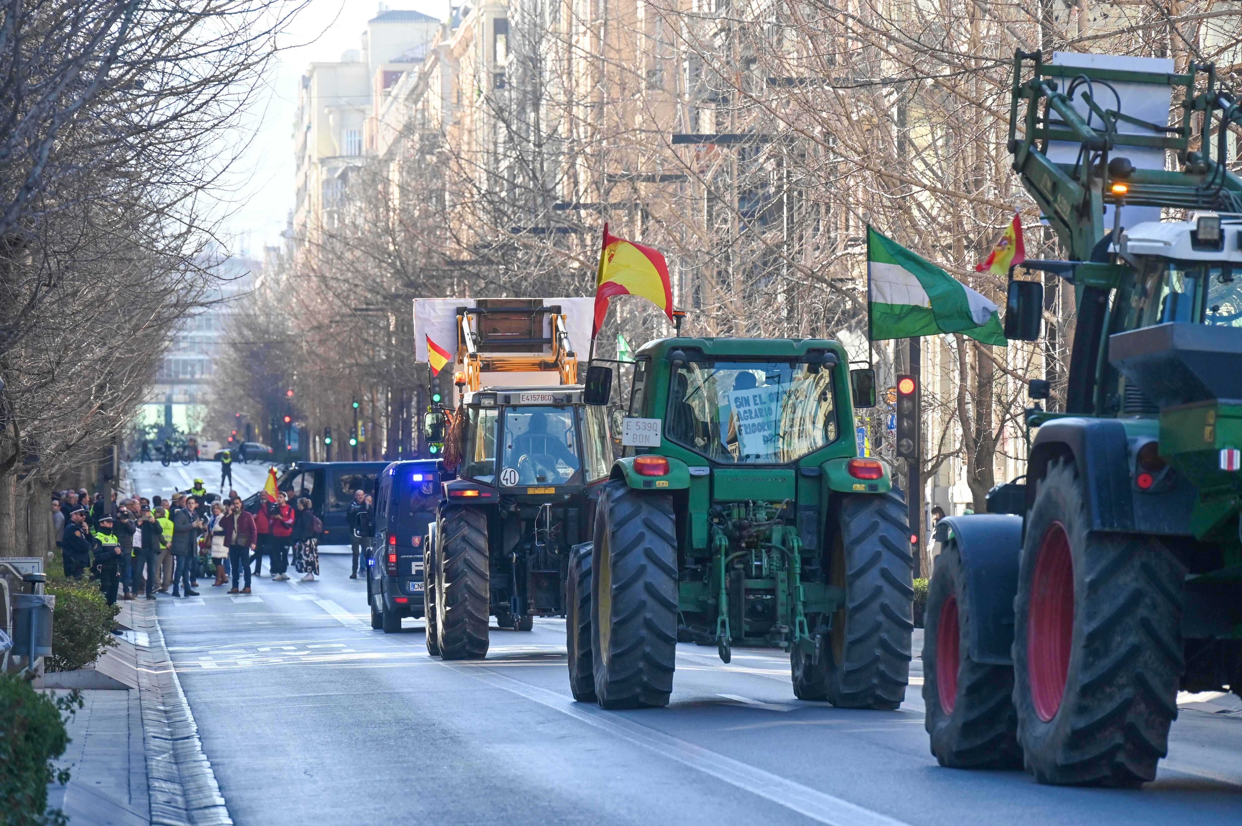 GRANADA, 20/02/2024.- La protesta de agricultores convocada para este martes en Granada por las principales organizaciones agrarias ha cortado al tráfico la céntrica Gran Vía, donde se ubica la Subdelegación del Gobierno, a cuyas puertas se han concentrado para reclamar medidas contra la crisis del campo. EFE/Miguel Ángel Molina
