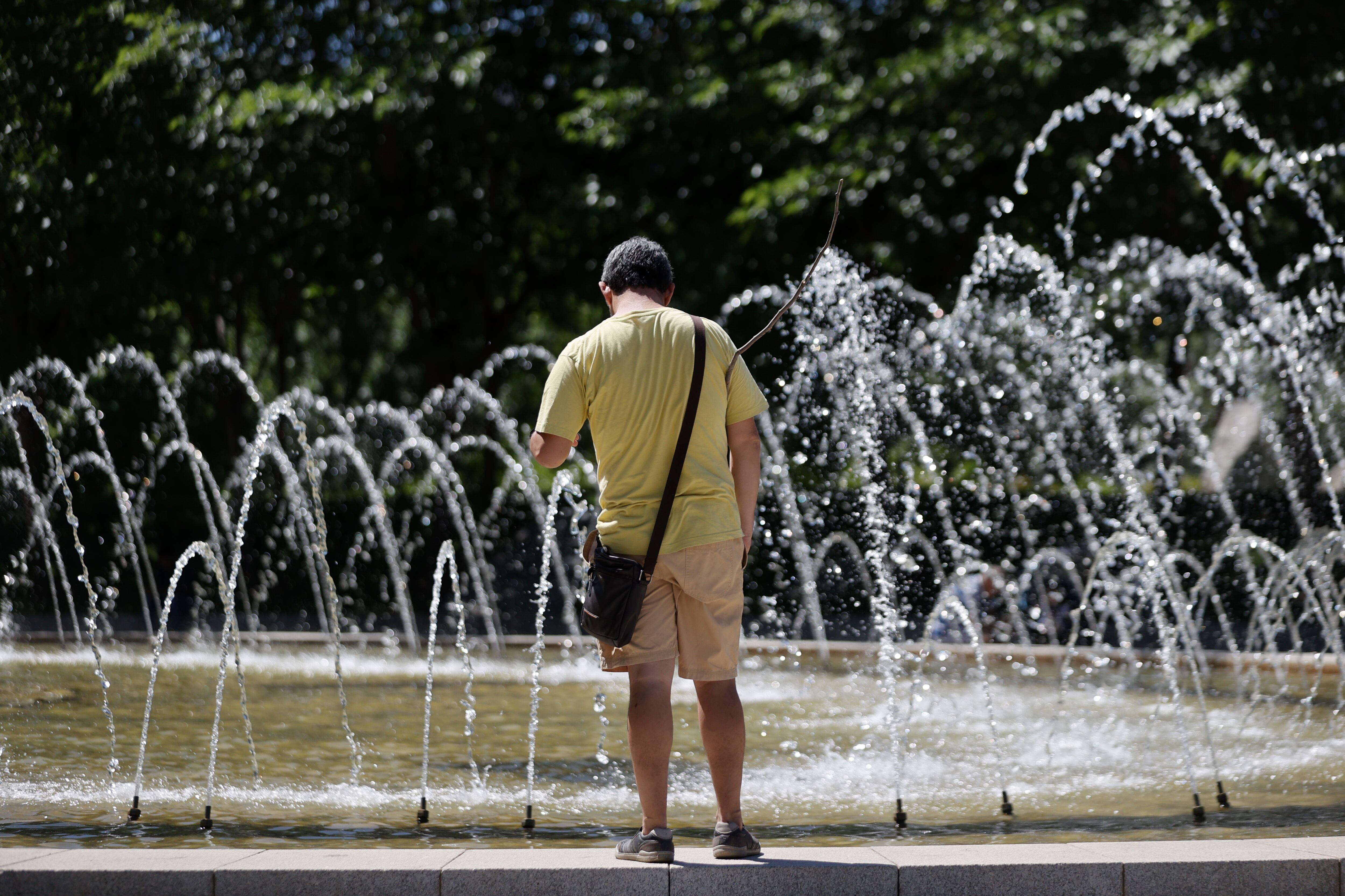 Un viandante se acerca a una fuente en un parque. El intenso calor volverá a ser protagonista