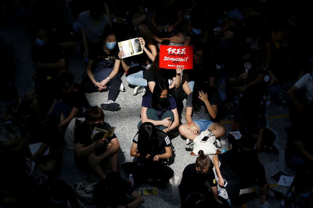 Protestantes sentados en una terminal del aeropuerto internacional de Hong Kong.