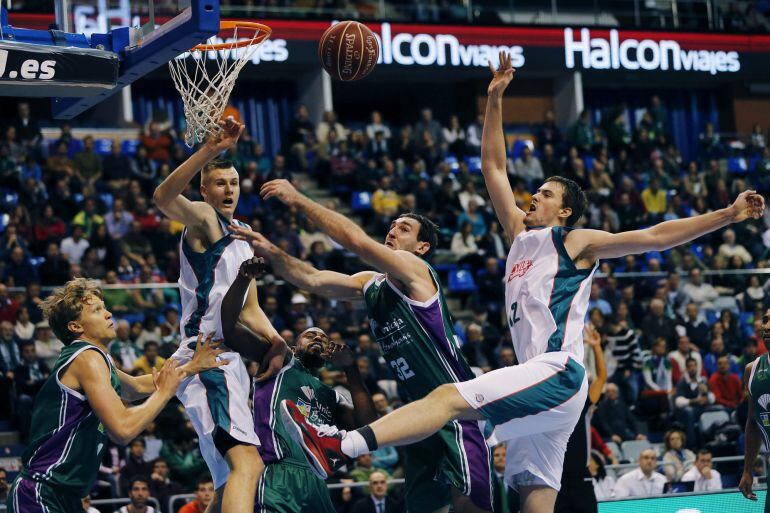 GRA180. MÁLAGA, 14/12/2014.- Los jugadores del Baloncesto Sevilla el ala-pívot letón Kripstas Pozingis (2i) y el pívot checo Ondrej Balvin (d) luchan por recuperar el balón ante los jugadores del Unicaja, el alero lituano Mindaugas Kuzminskas (i),el ala-pívot estadounidense Will Thomas(c) y el pívot montenegrino Vladimir Golubovic (2d), durante el encuentro de la undécima jornada de la Liga Endesa que ambos equipos disputan esta tarde en el Palacio de Deportes José María Martín Carpena, en Málaga. EFE/ Jorge Zapata 