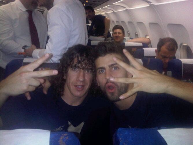 Piqué y Puyol celebran el título de liga en a bordo del avión