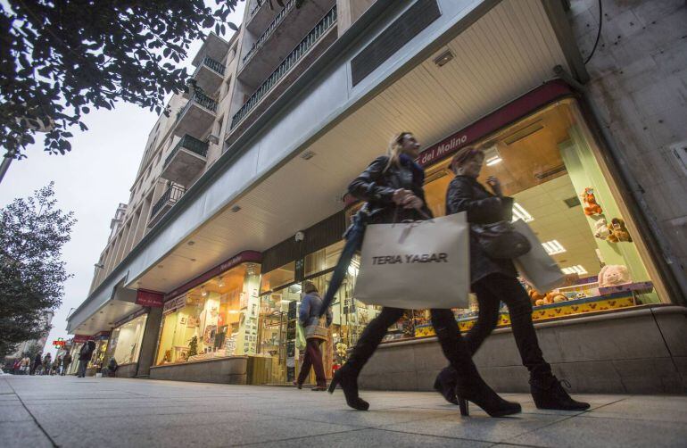 Dos personas con bolsas de compras en Santander