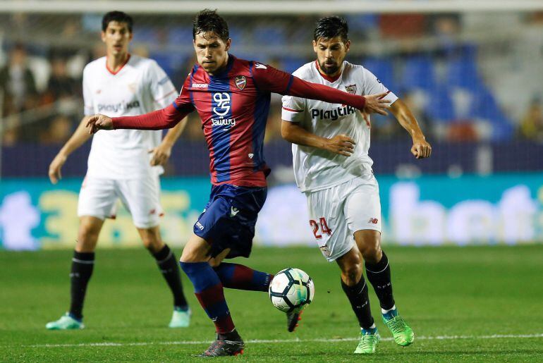 El centrocampista serbio del Levante Sasa Lukic (c) juega un balón ante Nolito, del Sevilla, durante el partido de Liga en Primera División que están disputando esta noche en el estadio Ciutat de Valencia. 