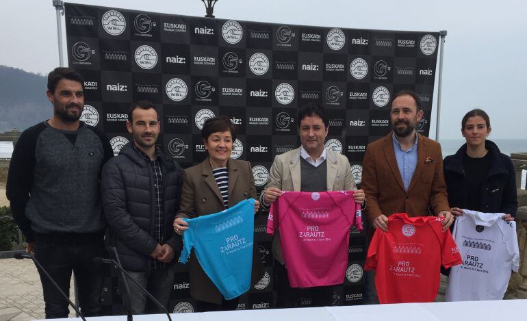 Responsable del campeonato y responsables instituciones posan con la playa de Zarautz detrás