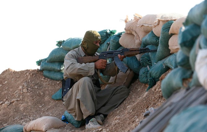 Un luchador Peshmerga kurdo vigila en la primera línea cerca de la ciudad de Khanaqin