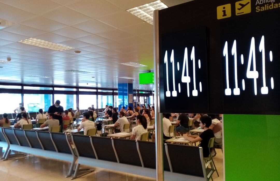 Cientos de alumnos comienzan su examen de Selectividad en uno de los pasillos de embarque del aeropuerto de Palma de Mallorca.