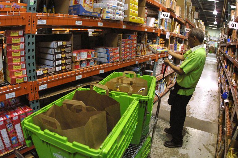 Un trabajador de un supermercado repone existencias. 