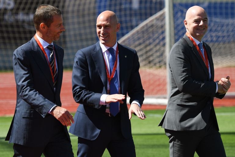 Rubiales saliendo de la Asamblea con el presidente de la FIFA y la UEFA