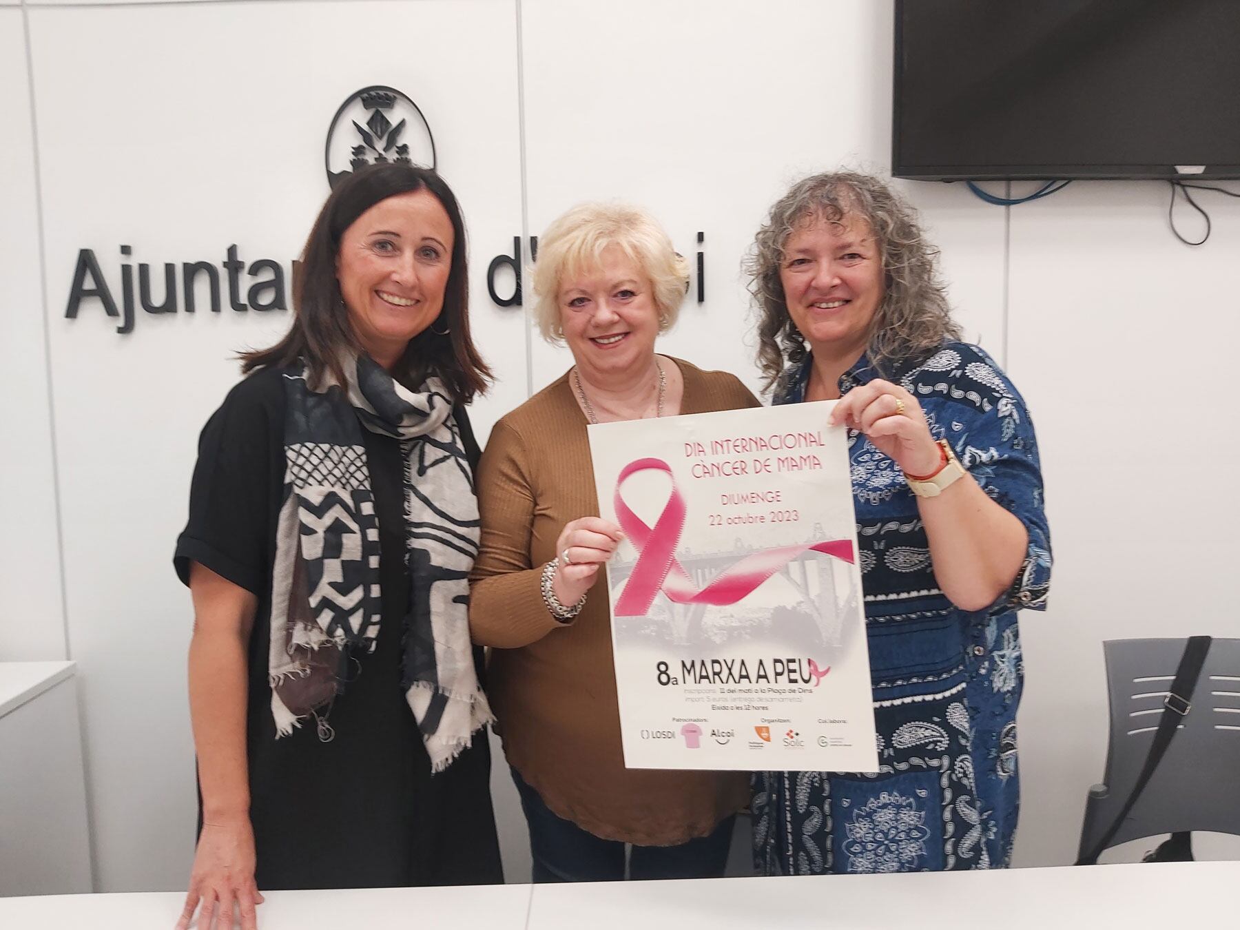 La concejal Aroa Mira, junto a Rosa Mari Payá y Marcela Ripoll, con el cartel de la octava edición de la marcha