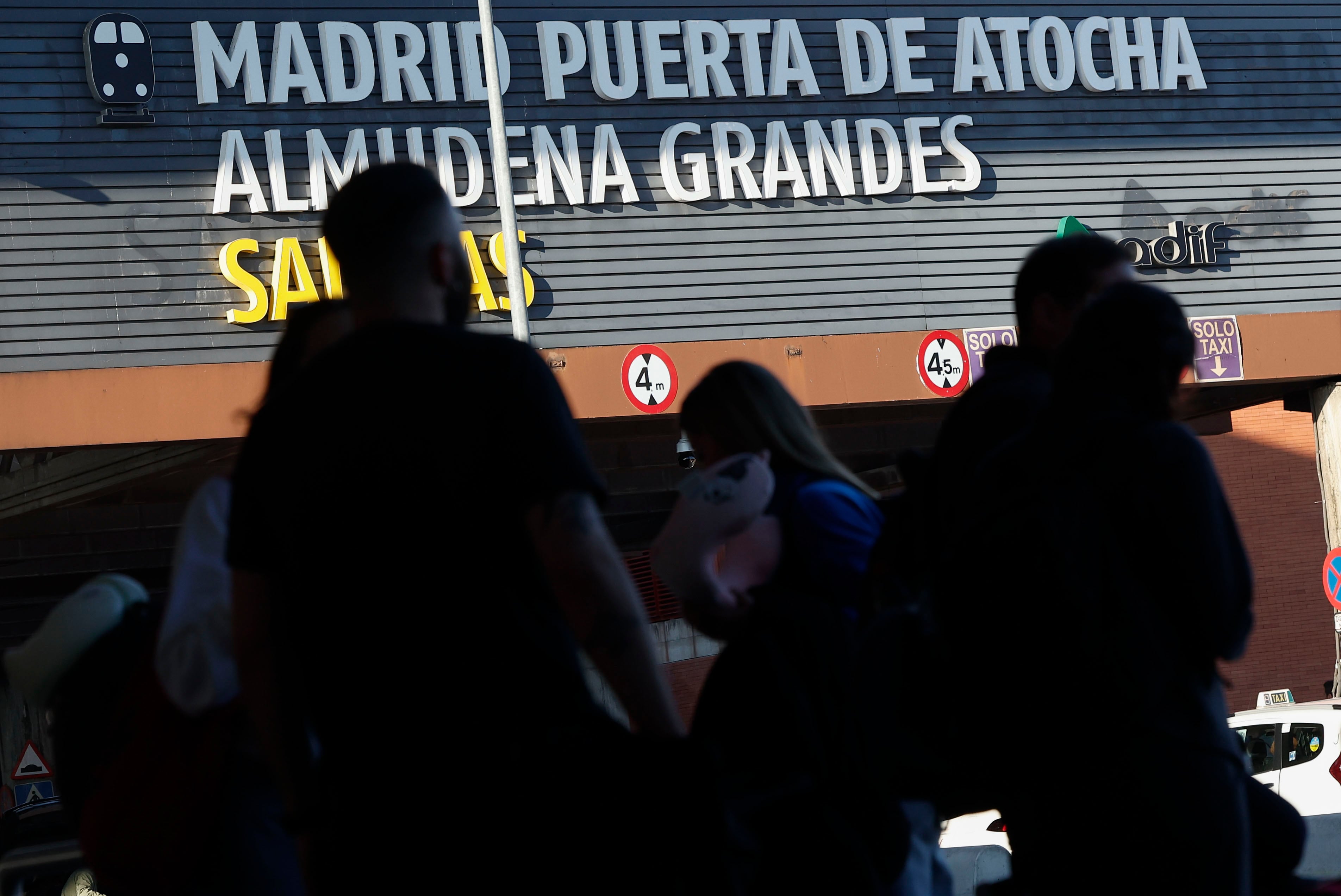 Varios viandantes pasan delante de uno de los accesos a la estación de Madrid Puerta de Atocha Almudena Grandes