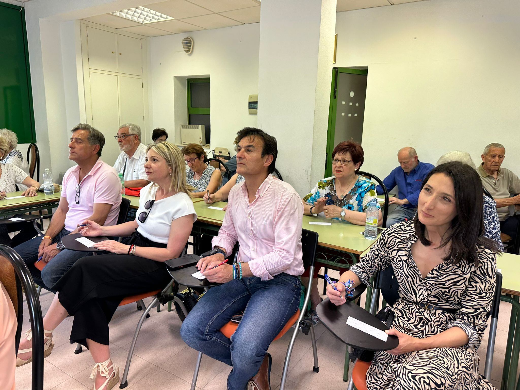 El candidato del PP de Jaén, Agustín González, junto a miembros de su partido durante una partida de bingo en el barrio de Santa Isabel