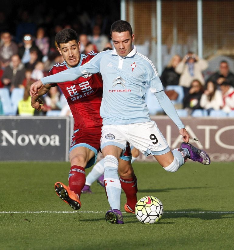 El delantero del Celta de Vigo Iago Aspas (d), autor del gol, pelea un balón con el defensa de la Real Sociedad Yuri Berchiche durante el partido correspondiente a la vigésima novena jornada de Liga jugado en el estadio de Balaídos, en Vigo