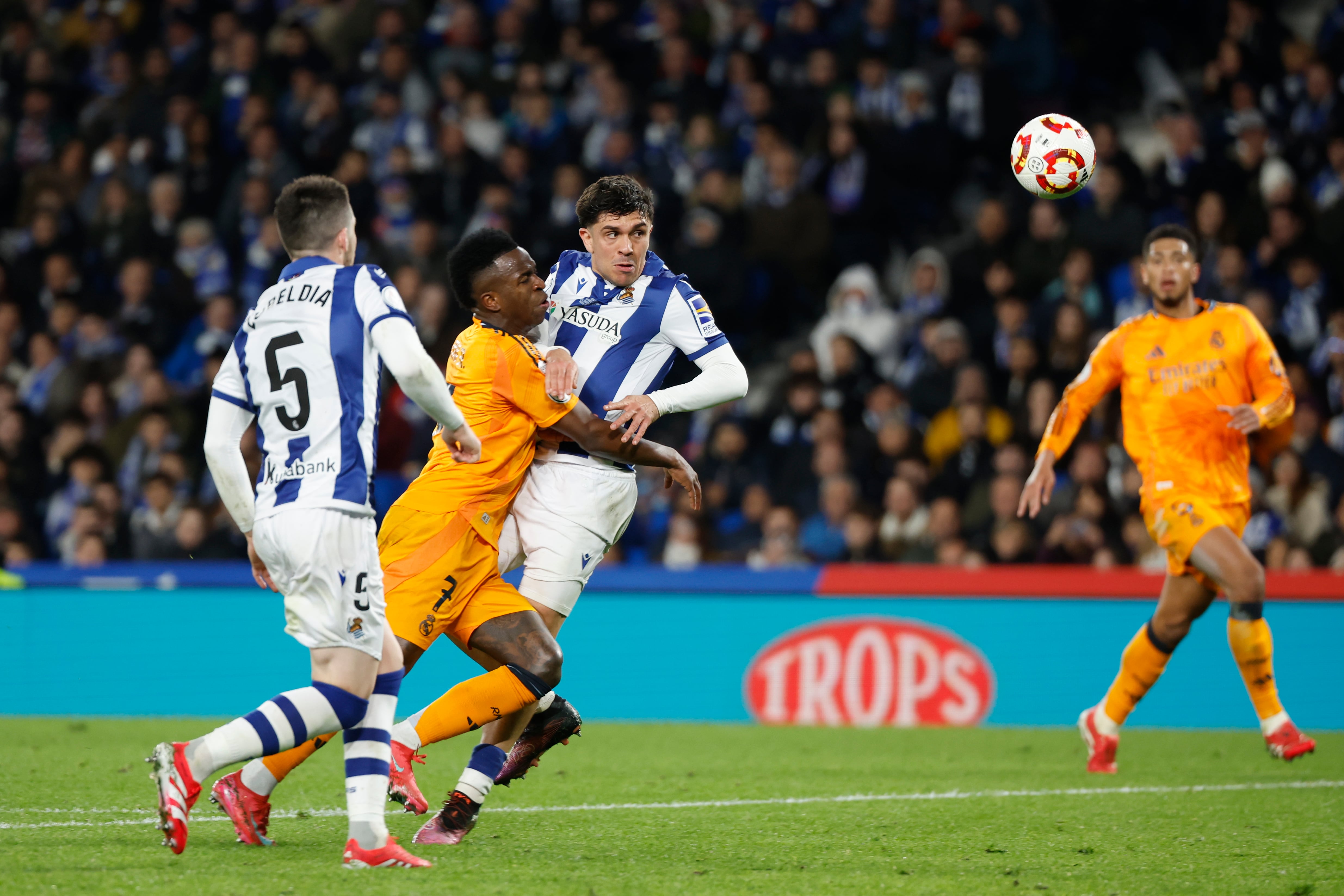 SAN SEBASTIÁN, 26/02/2025.- El delantero brasileño del Real Madrid, Vinicius Junior (2i), disputa el balón ante el centrocampista de la Real Sociedad, Pablo Marín, durante el encuentro correspondiente a la ida de las semifinales de la Copa del Rey que disputan hoy miércoles Real Sociedad y Real Madrid en el estadio de Anoeta, en San Sebastián. EFE / Juan Herrero.
