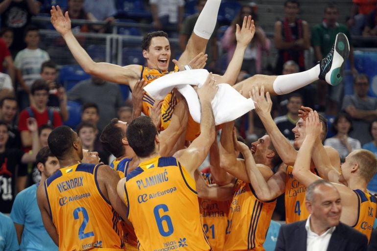 Los jugadores del Herbalife Gran Canaria mantean al alero estadounudense Kyle Kuric.