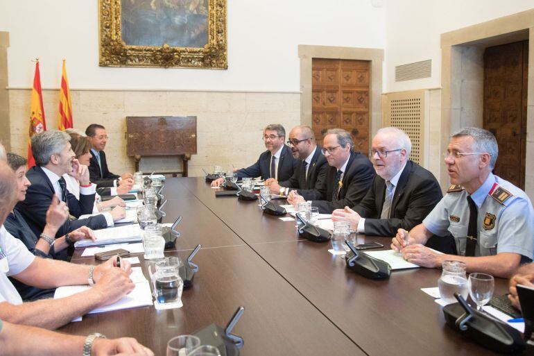 El presidente de la Generalitat , Quim Torra, junto al conseller de Interior Miquel Buch, en la parte derecha de la mesa junto al ministro de Interior, Fernando Grande-Marlaska.