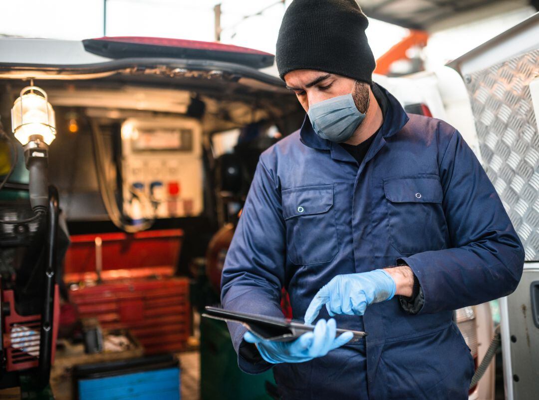 Mecánico de coches usando mascarilla y guantes protectores