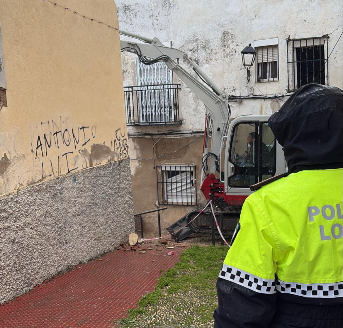 Un policía local supervisa el derrumbe de la casa abandonada en la calle Positillo de Jaén.