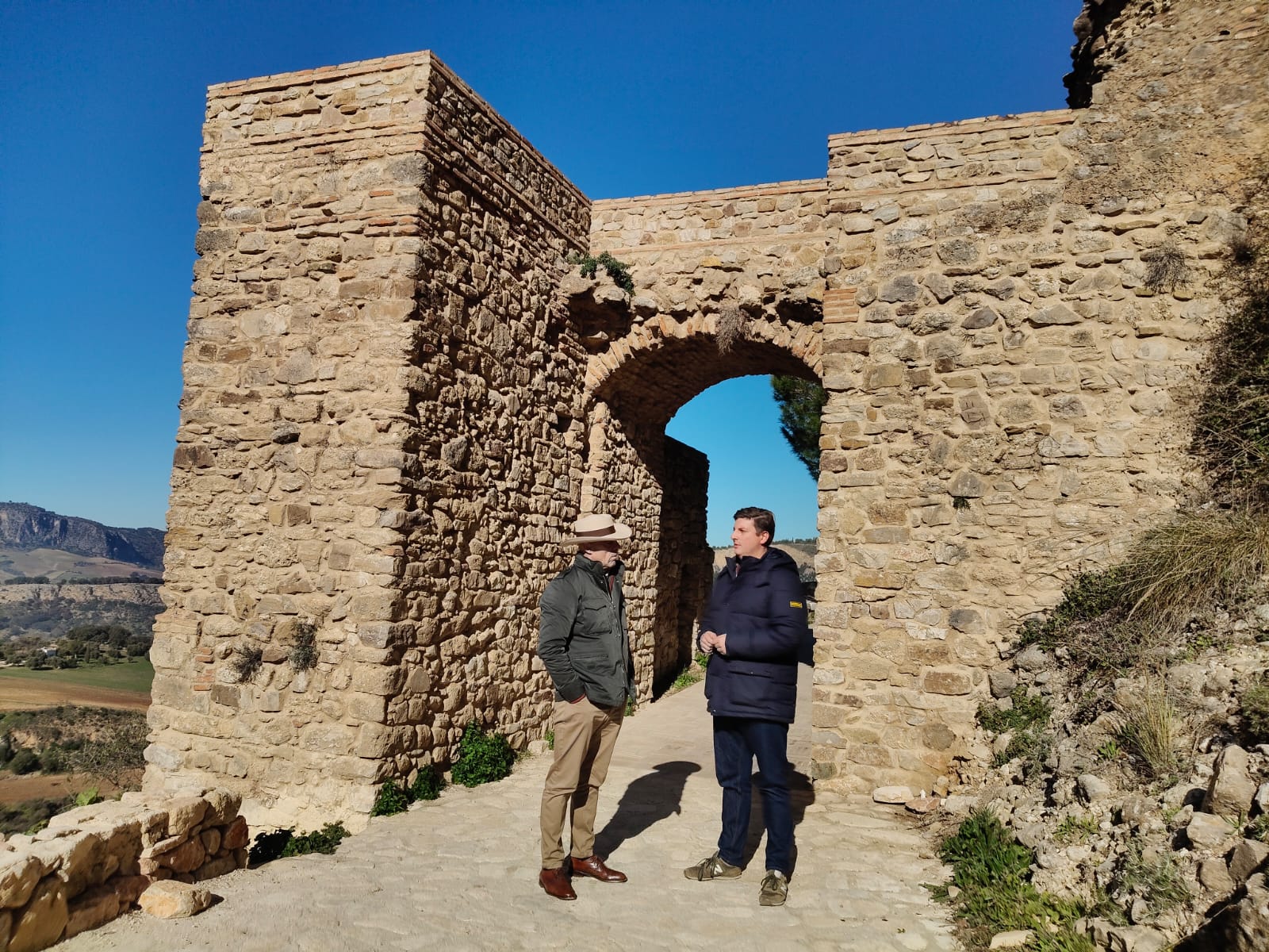 El cronista oficial de Ronda, Faustino Peralta, junto al concejal de Patrimonio, Jorge Fernández, en la Puerta del Viento