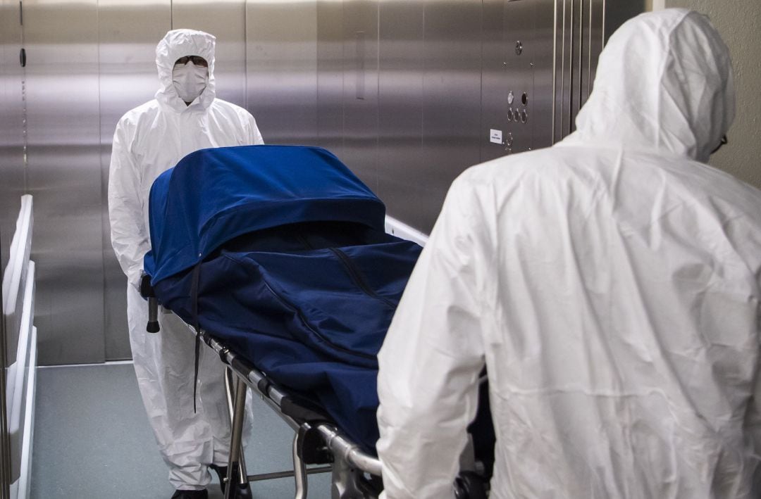 Dos empleados llevan el cuerpo de una persona en Estados Unidos. 