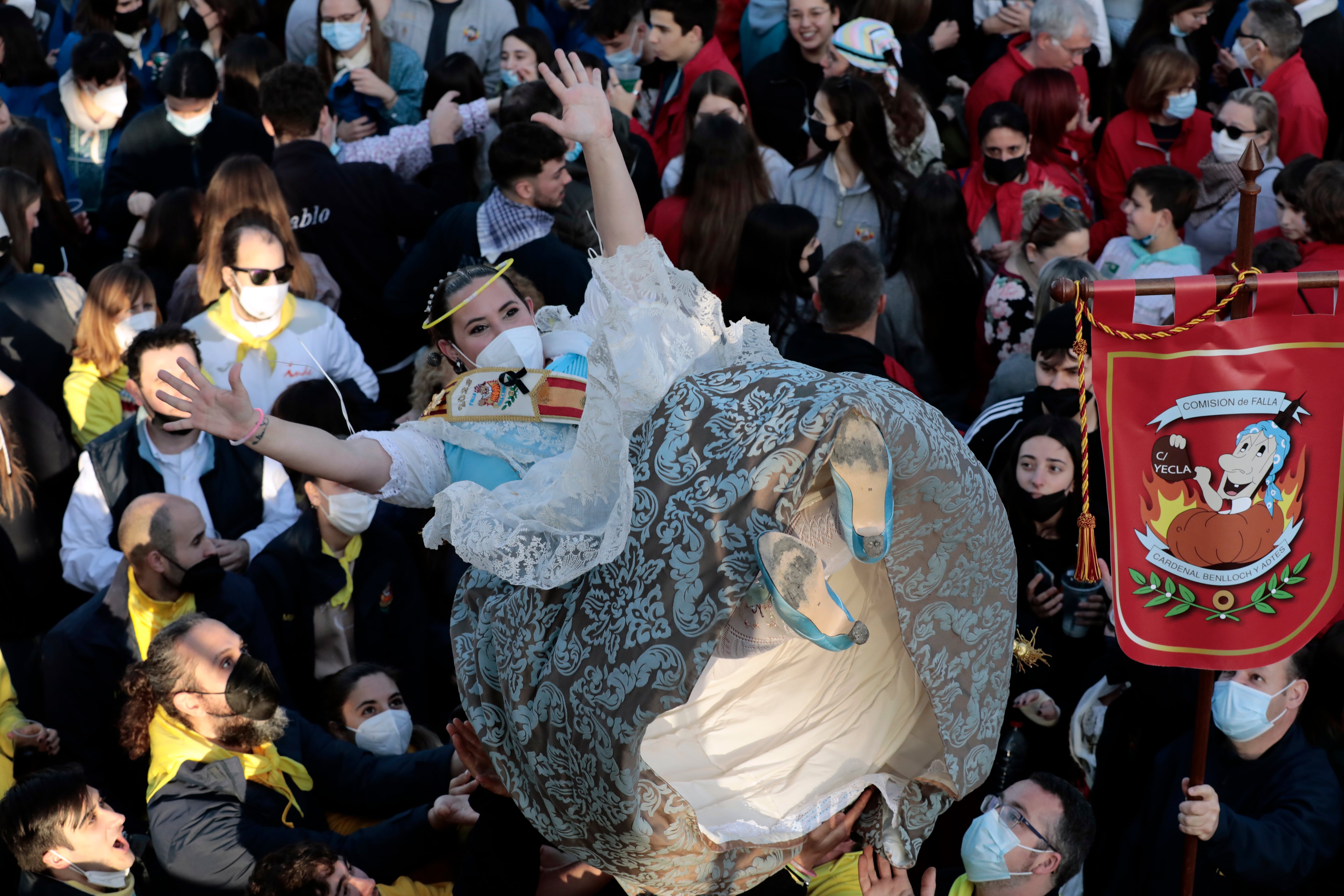 Una fallera es manteada durante la Crida en las Torres de Serranos con la que arrancan este domingo Las Fallas de València, un acto en el que no habrá límite de aforo, pero en el que el público asistente deberá utilizar la mascarilla como medida de protección ante la covid.