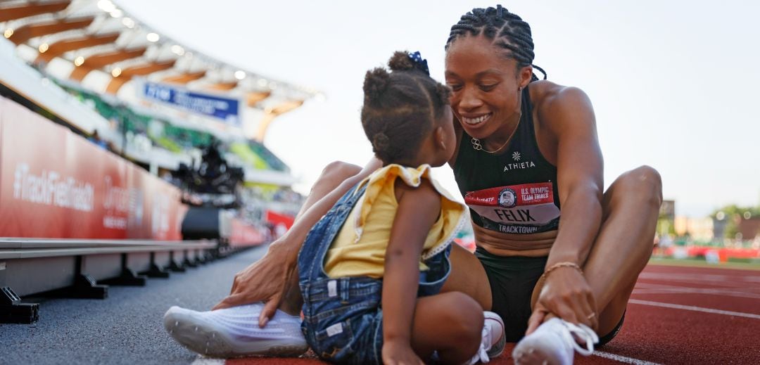 Allyson Felix juega con su hija en una pista de atletismo