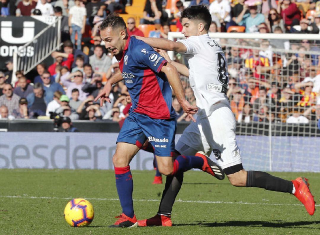 Carlos Soler pelea por un balón ante el Huesca