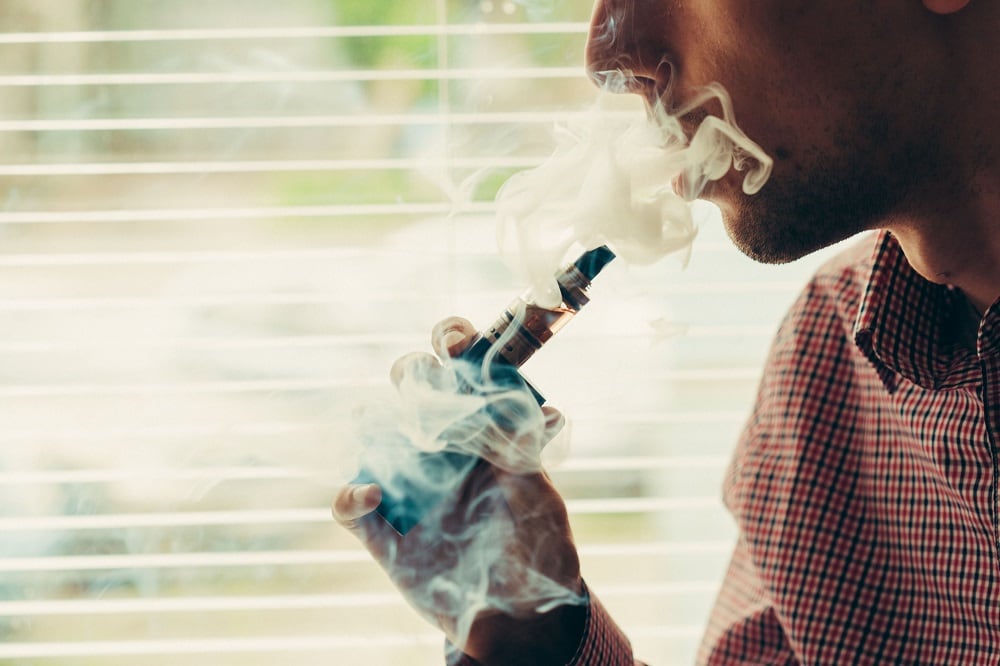 Close up on a man exhaling vapor from an electronic cigarette