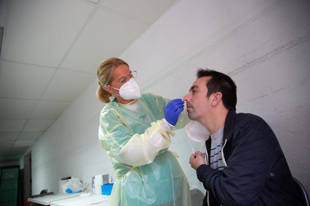 Una sanitaria realiza un test de antígenos o una PCR a un hombre. Archivo