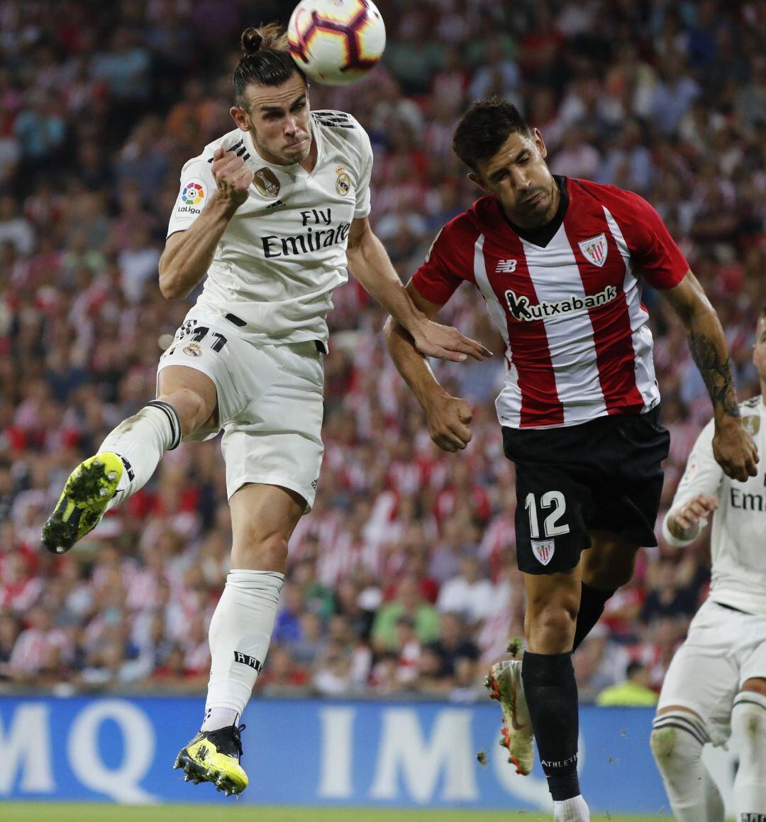 El delantero galés del Real Madrid Gareth Bale (i) remata ante el defensa del Athletic Yuri Berchiche