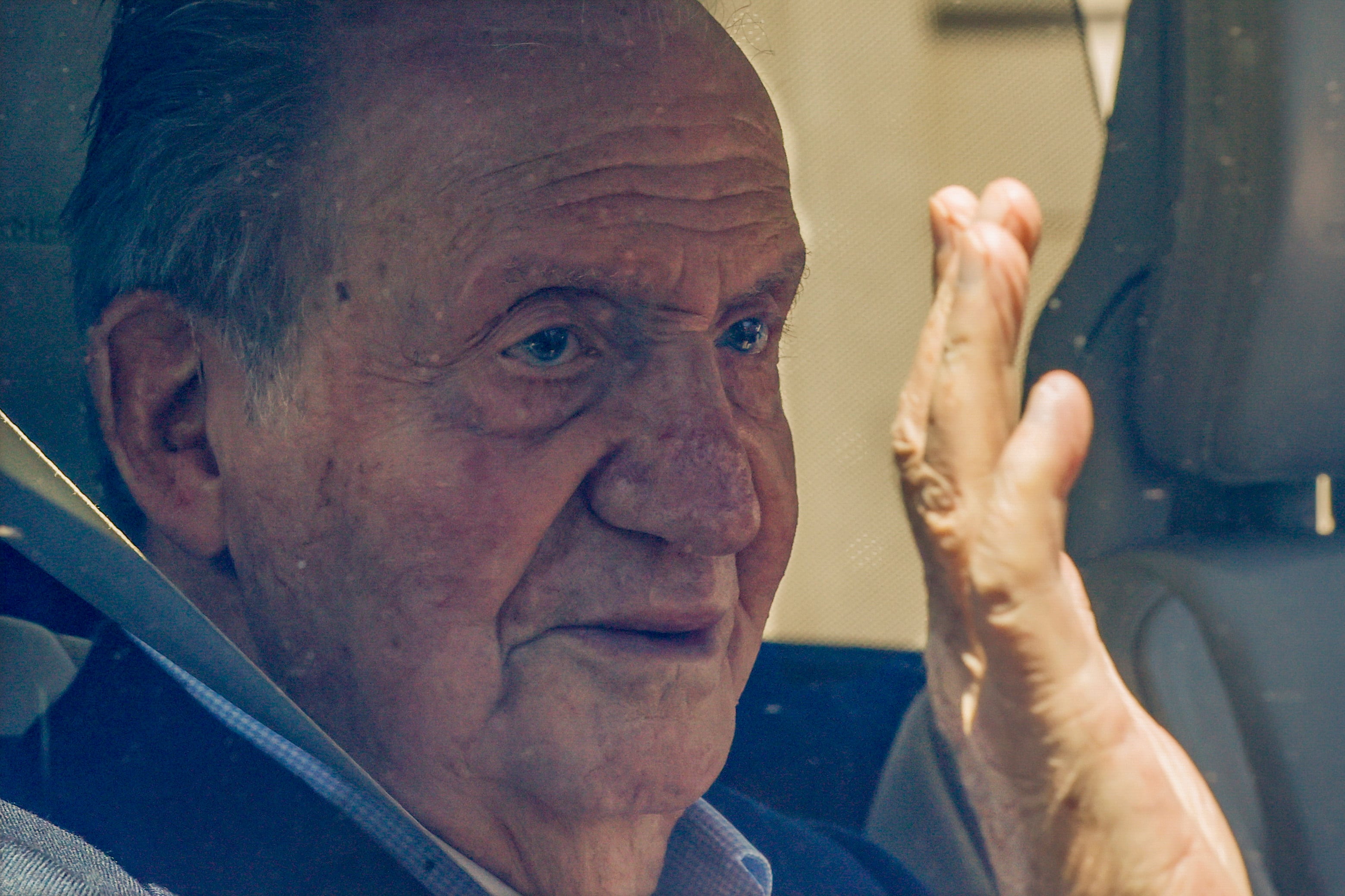 El rey Juan Carlos saluda a la prensa a su llegada a la casa de su amigo y regatista Pedro Campos