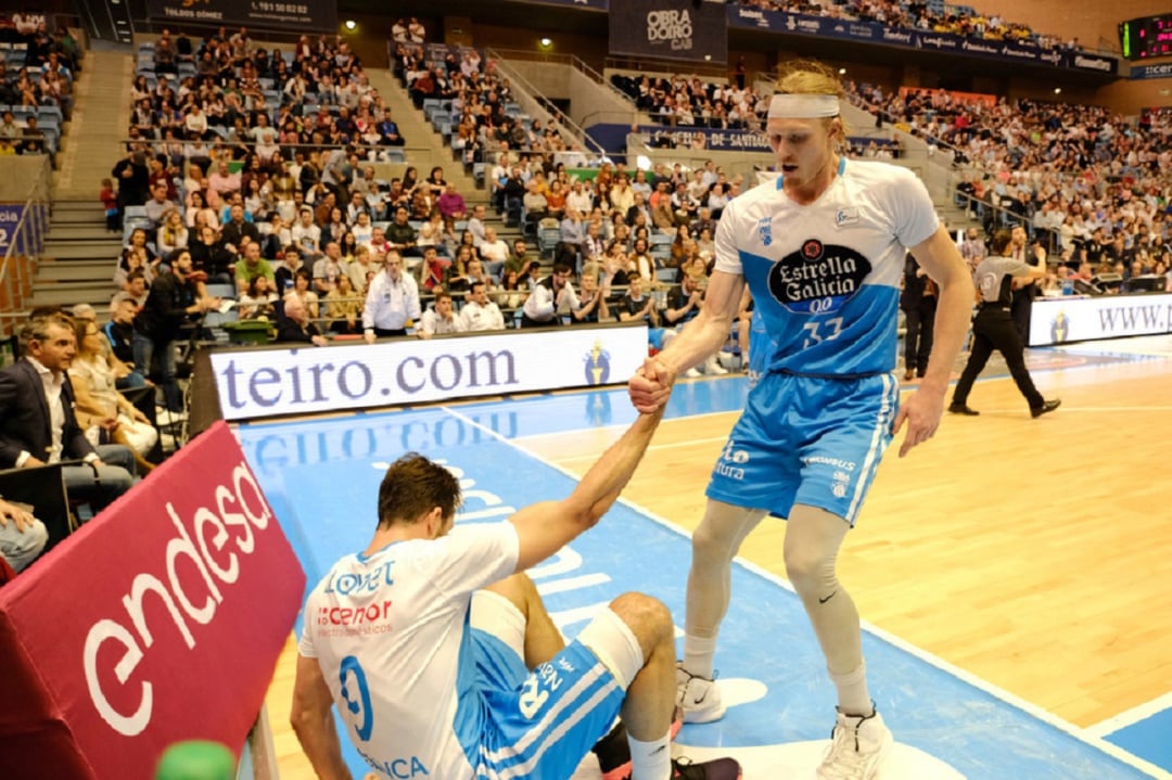 Singler ayuda a levantarse a su compañero Nacho Llovet en el duelo ante Tenerife