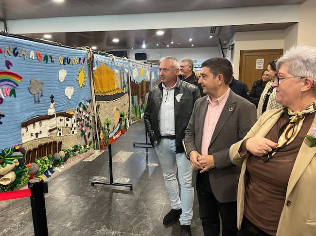 Visita de Paco Reyes a la exposición en IFEJA, acompañado por el presidente de la ADR Sierra Mágina, Antonio Morales, y mujeres que han participado en la iniciativa 'Enganchadas por un hilo'