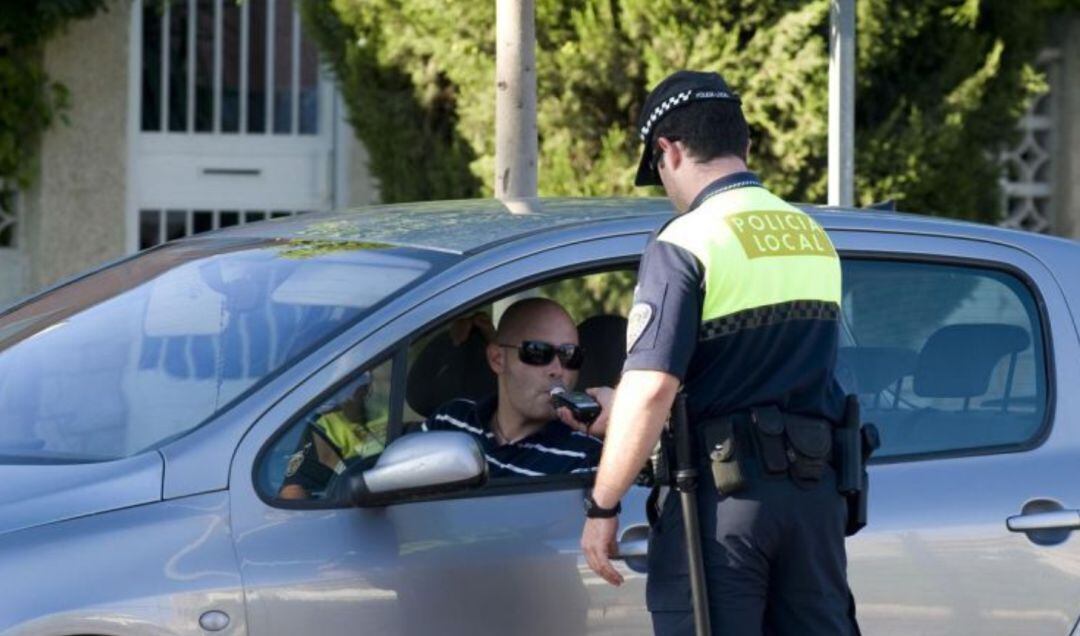 Un agente realiza un control de alcoholemia a un conductor. 