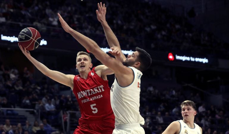 El base esloveno del Fuenlabrada Luka Rupnik (i) entra a canasta ante Felipe Reyes (c), del Real Madrid, durante el partido de la Liga ACB disputado en el Palacio de los Deportes.