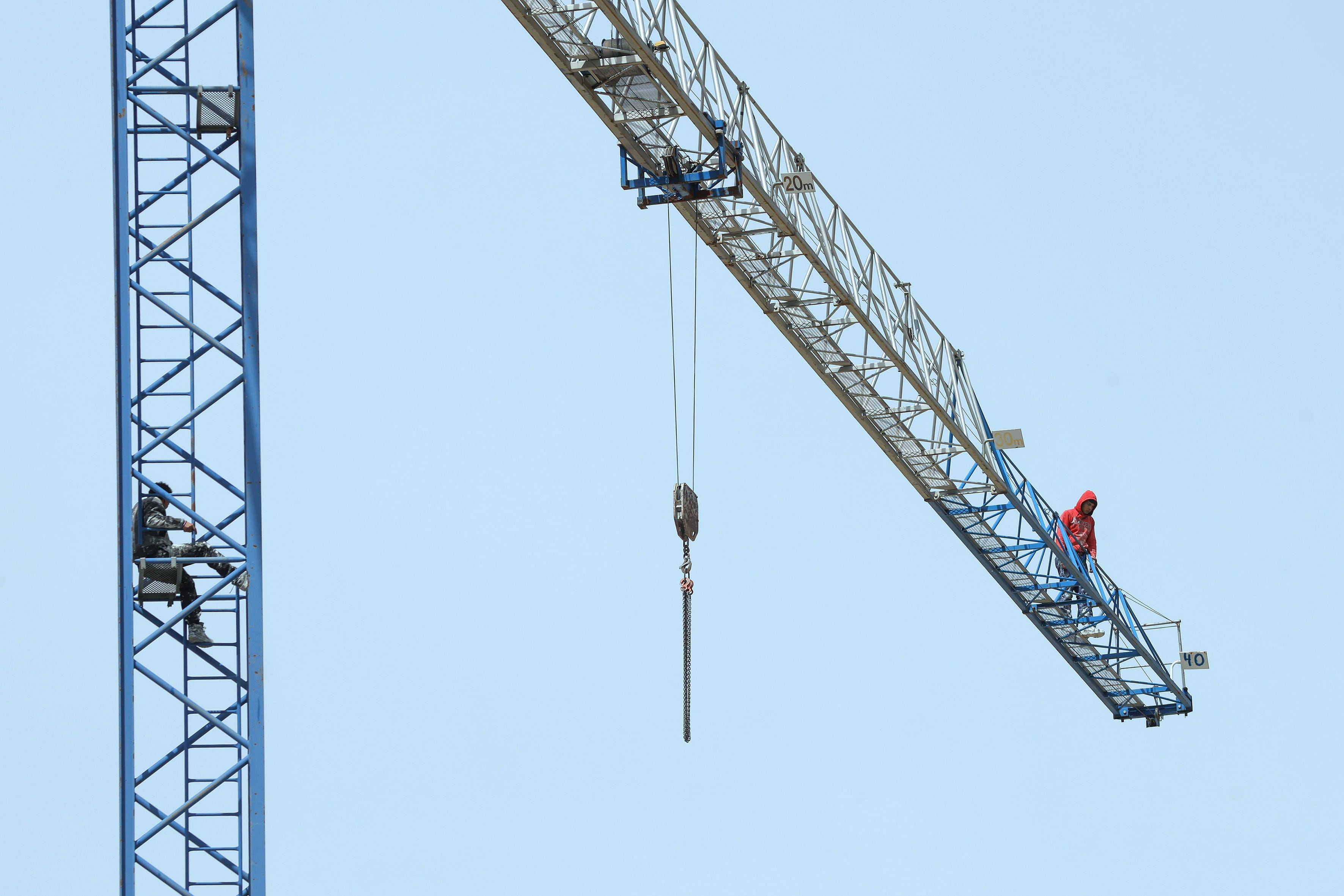Burgos, 18/04/2026.- Dos trabajadores de la construcción se han encaramado este sábado a una grúa, a unos cuarenta metros del suelo, para exigir el pago de sus salarios, en el barrio Fuentecillas, en el parque de los Ochos de la capital burgalesa. EFE/Santi Otero