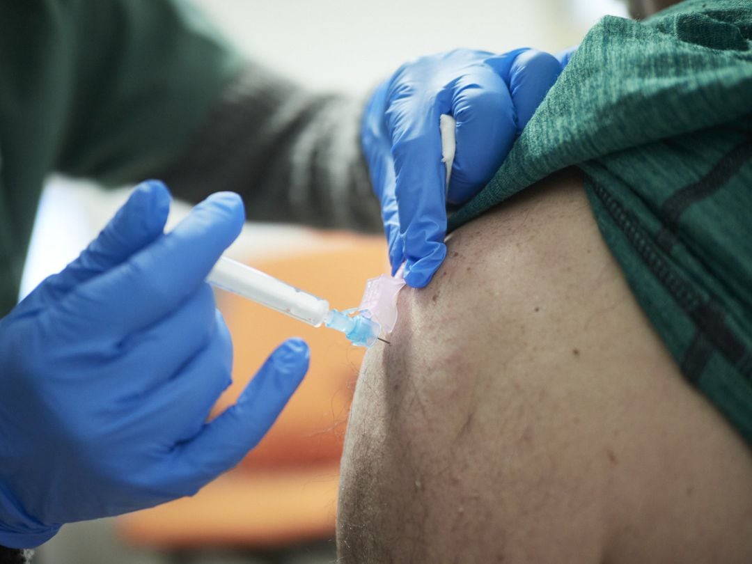 Una sanitaria vacunando a un paciente contra la COVID-19