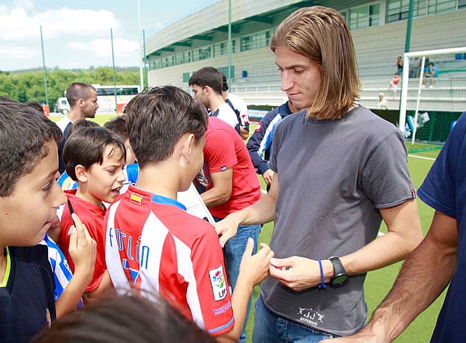 Filipe Luis saluda a un niño vestido con la camiseta del Atlético de Madrid