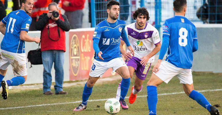 Mario Martos, del Linares Deportivo, conduce la pelota presionado por Víctor Andrés, del Real Jaén, en el derbi entre el Linares y el Real Jaén jugado en la temporada anterior. 