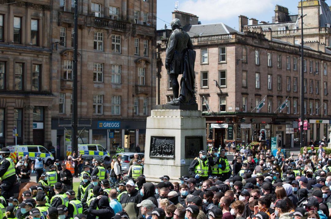 Protesta al lado de una estatua en Escocia.