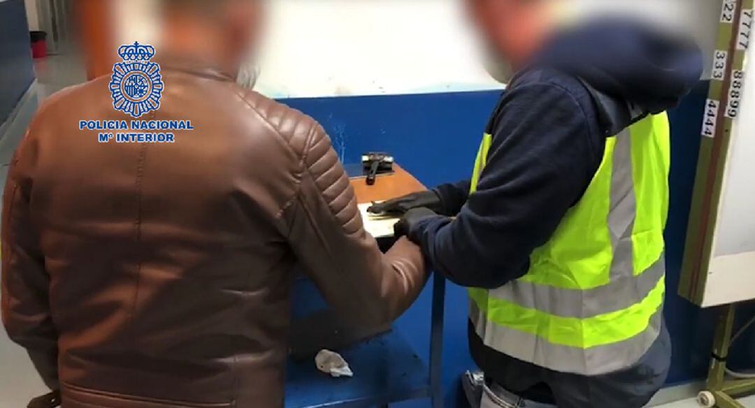 Un agente toma huellas a uno de los detenidos.