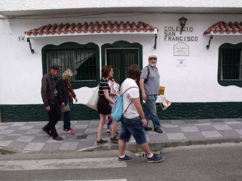 Moriche acompaña a varios turistas que pasan por al Colegio San Francisco en la Bajadilla.