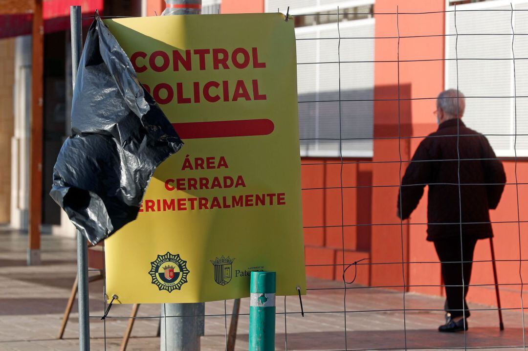 Una persona mayor ante un cartel en la localidad valenciana de Paterna..El cierre perimetral de los municipios de más de 50.000 habitantes se aplica desde las 15 horas de este viernes y hasta las 6 horas del lunes