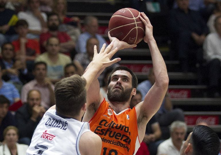 El alero del Valencia Basket, Fernando San Emeterio, lanza a cansta ante el base esloveno del Real Madrid, Luka Doncic, durante el tercer partido de semifinales de la Liga que han disputado en el pabellón Fuente San Luis de Valencia.