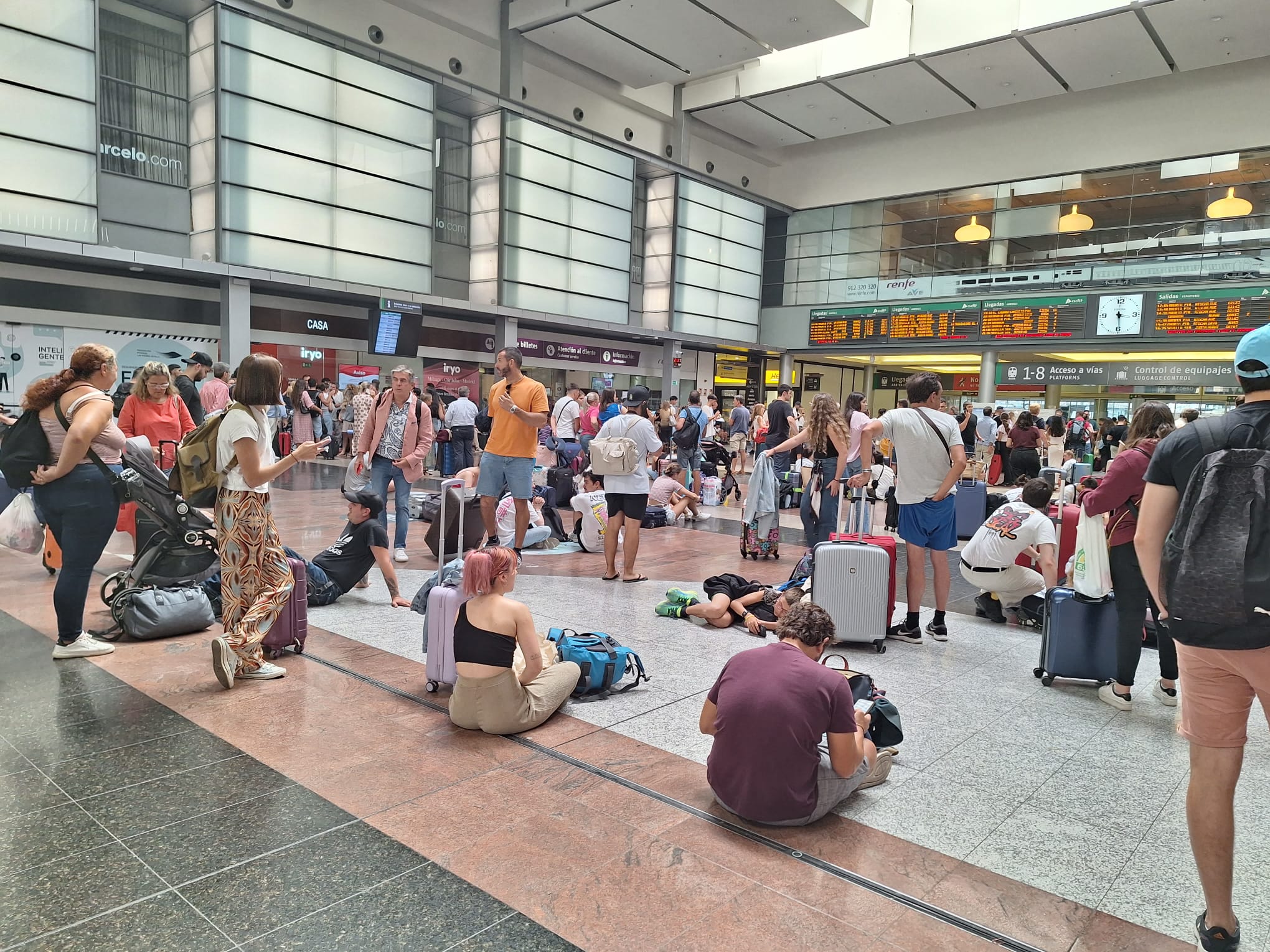 Estación María Zambrano este lunes, a mediodía, con cientos de viajeros esperando tomar un tren