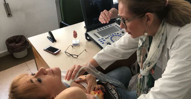 Doctora realizando una ecografía de tiroides a una paciente.