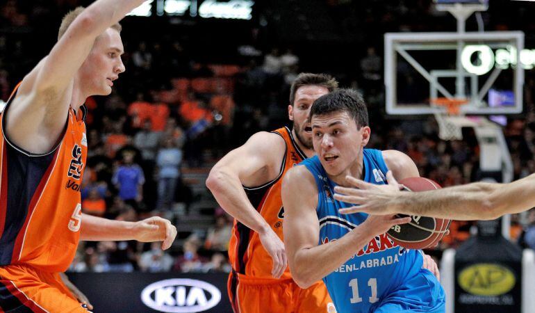 Los jugadores del Valencia Basket, el pívot islandés, Tryggvi Hlinason (i), y el base belga, Sam Van Rossom (c), tratan de defender al escolta del Montakit Fuenlabrada, Francisco Cruz (d), durante el partido correspondiente a la jornada 17ª de la liga ACB