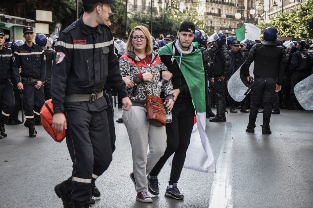 La Policía arresta a una manifestante en una protesta ante un centro electoral en Argel durante las elecciones presidenciales.