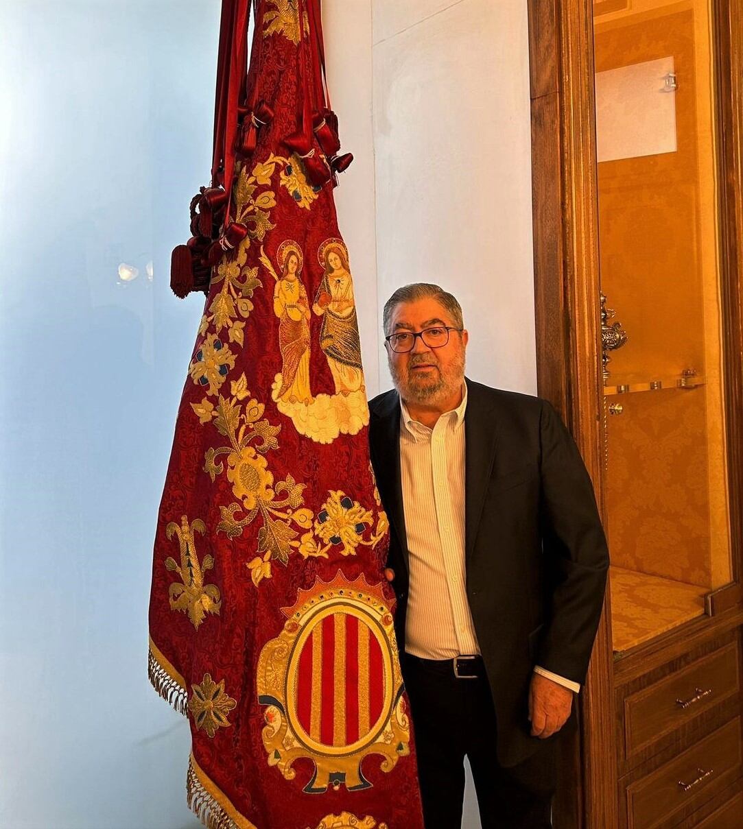 Baldomero, junto a la bandera de Orihuela.