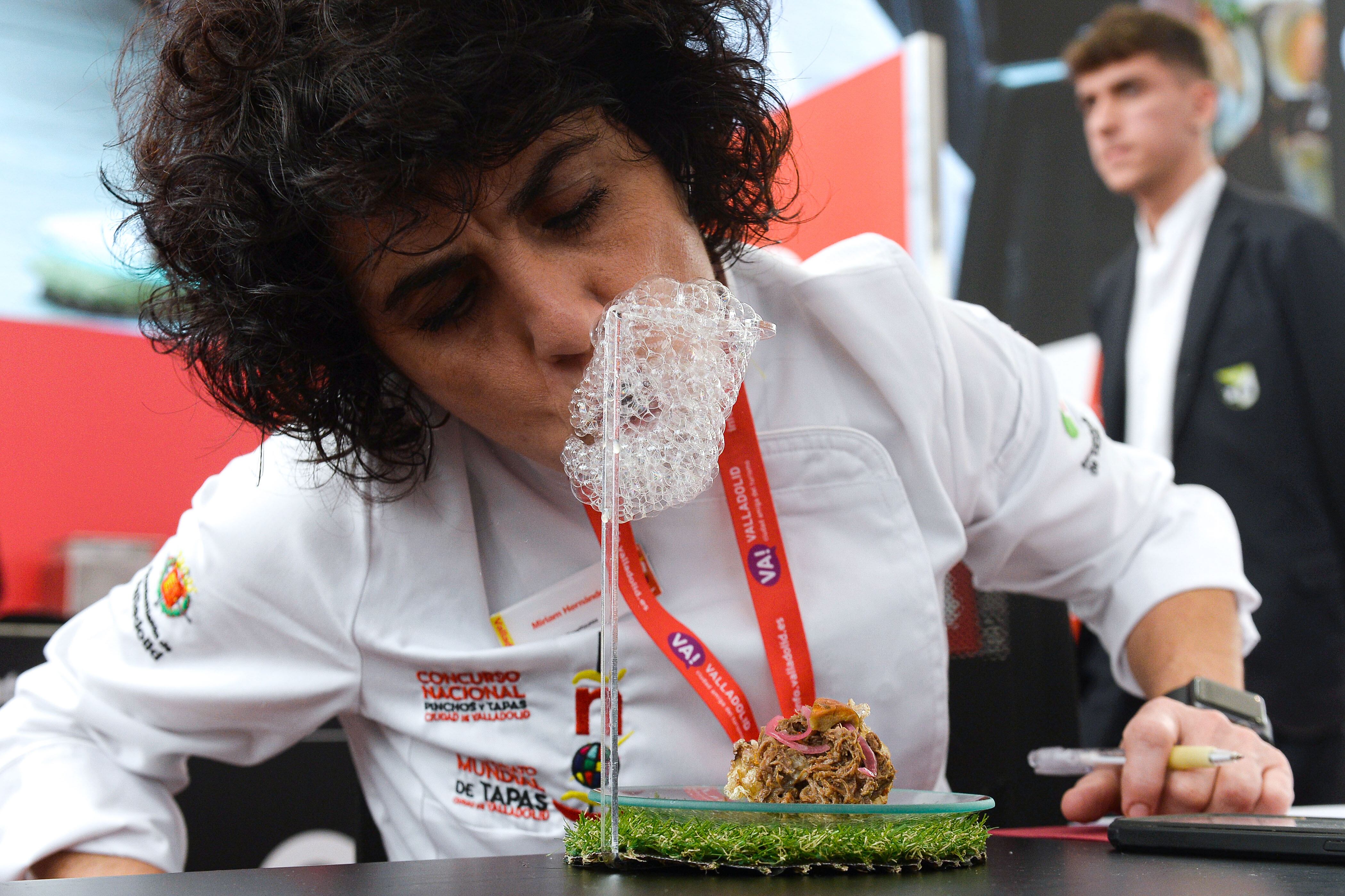 La cocinera Miriam Hernández, miembro del jurado, prueba &quot;Cachena&quot;, con el que María Bermejo del establecimiento leonés Dehesa La Cenia, participa en el XVIII Concurso de Nacional de Pinchos y Tapas que se celebra en Valladolid. EFE/Nacho Gallego